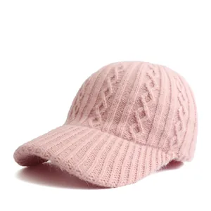 Detail of cable-knit texture and ribbed brim on light pink winter baseball cap