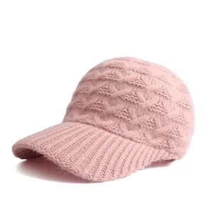 Nahaufnahme der rosa Strickmütze mit Zopfmuster-Textur und gebogenem Schirm