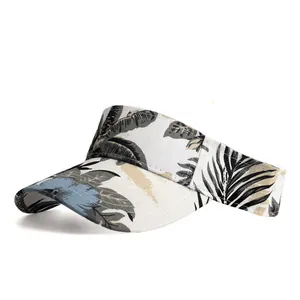 Detail view of tropical leaf print and textured fabric on off-white sun visor hat