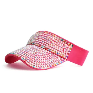 Detail of bright pink sun visor with colorful rhinestones on a white background