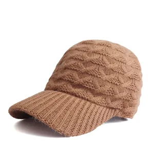Detail der kamelfarbenen Strickmütze mit Zopfmuster und geripptem Schirm