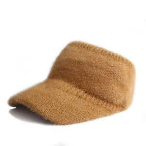 Dettaglio macro del cappello in maglia color cammello con soffice trama di pelliccia