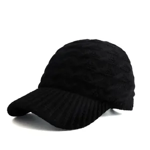 Detail einer schwarzen Strick-Basecap mit dickem Wellenmuster und gerippter Krempentextur