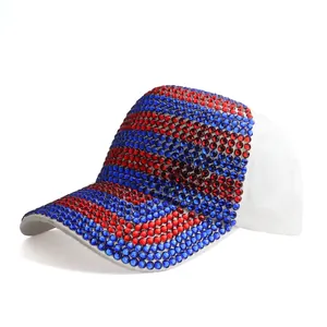 Detailed view of red and blue rhinestones on a white glittery baseball cap