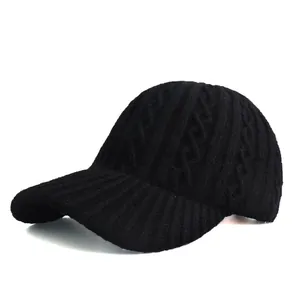 Close-up of black cable knit baseball cap showing thick texture and striped brim pattern