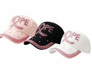 Detailaufnahme der HOPE Strass-Baseballkappen in Pink, Schwarz und Weiß mit Herzschleife