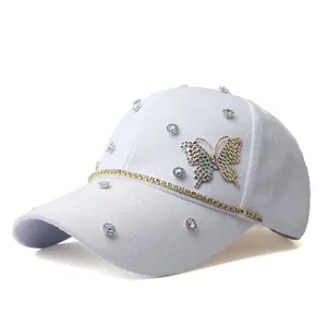 Detail of white baseball cap with rhinestone butterflies and luxury jacquard texture