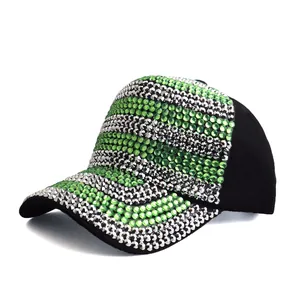 Detailed view of green and silver rhinestones on a black cotton baseball cap surface