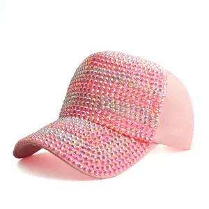 Detailed view of pink baseball cap with sparkling colorful rhinestones on a white background