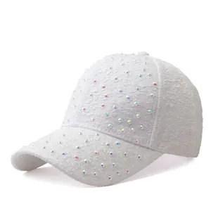 Détail de la casquette en dentelle blanche avec broderie florale et strass irisés