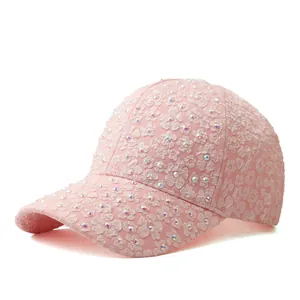 Gros plan d'une casquette en dentelle rose avec strass brillants et broderie florale