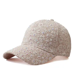Détail du motif en dentelle florale et strass colorés sur la casquette beige brodée