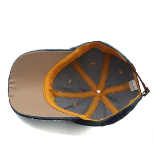 Detail view of denim baseball cap interior with yellow seam tape and cotton wash label