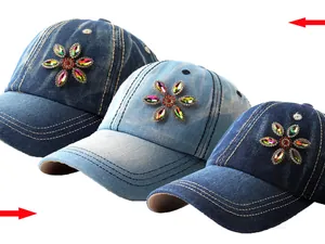 Detailed shot of sparkling rhinestone flower embroidery on denim baseball caps in three blues