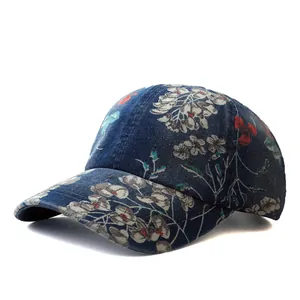 Detailed close-up of dark blue denim baseball cap featuring vintage floral patterns