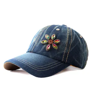Close-up of a floral rhinestone pattern on a dark blue denim baseball cap with sun protection