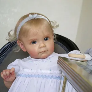 Realistische Toddler Maggi Puppe mit blonden Locken, blauen Augen und Blumenkleid