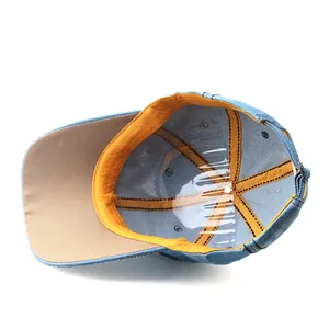 Detail view of denim baseball cap interior with yellow sweatband and khaki underbrim