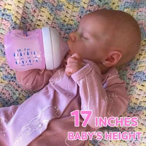 Realistic 17-inch sleeping reborn baby doll in pink romper with bottle on woven mat