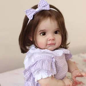 Poupée reborn réaliste avec cheveux bruns, robe à carreaux violets et peau détaillée