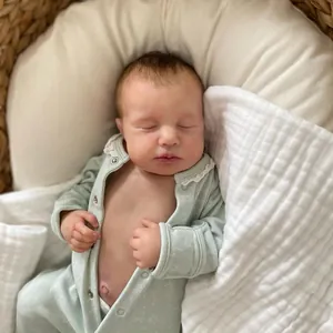 Lifelike 49cm reborn baby doll Loulou in floral green outfit sleeping in a woven basket