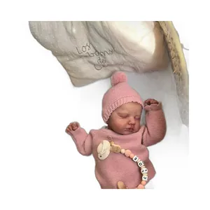 Realistic 19-inch newborn reborn doll LouLou sleeping in pink knitted outfit with Chloe pacifier