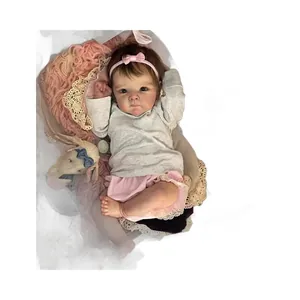 Lifelike 18-inch reborn baby doll in gray shirt and pink lace tutu on soft plush rug