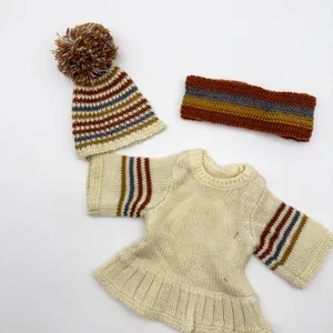 Detailed view of striped 3-piece knit doll outfit with pompom hat and headband