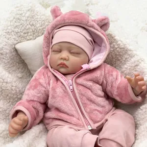 Detailed view of 55cm reborn baby doll sleeping in pink plush hooded outfit and hat