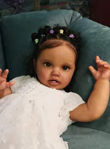 Gros plan d'une poupée reborn réaliste de 60 cm avec yeux bruns et cheveux bouclés
