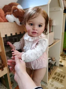 Close-up of lifelike 26-inch reborn baby doll skin texture and floral fabric detail