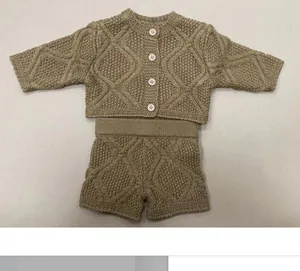 Macro shot of khaki knit two-piece baby doll outfit with textured diamond patterns