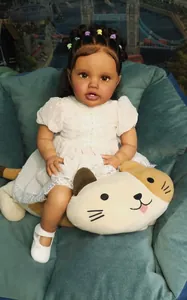 Détail de poupée reborn 60cm à la peau foncée, cheveux bouclés noirs et robe en dentelle