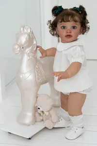 Close-up of 26-inch realistic toddler doll with blue eyes and brown curly hair