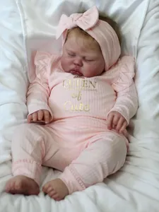 Detail of reborn baby doll in pink striped bodysuit with Queen of Cute gold print