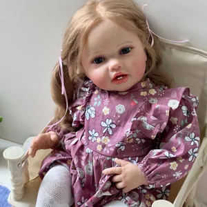 Reborn baby doll Lottie 60cm with blonde hair and purple floral dress on chair