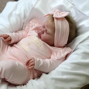Realistic 24-inch reborn baby doll in pink ribbed bodysuit with Queen of Cute print