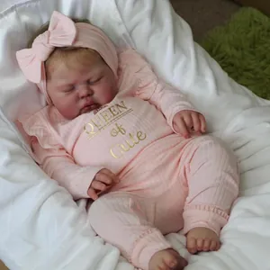 60cm realistic reborn baby doll in pink Queen of Cute outfit sleeping on white bedding