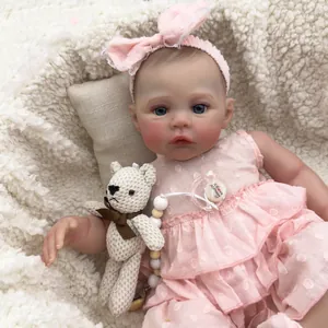 Lifelike 49cm reborn baby doll with 3D skin, pink polka dot dress and woven bear toy