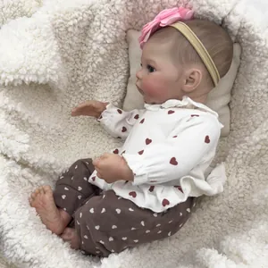 Realistic 46cm reborn baby doll Meadow in heart print outfit lying on soft white fleece
