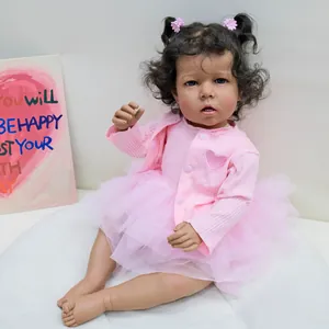 Macro detail of reborn baby doll with curly black hair and pink knit cardigan