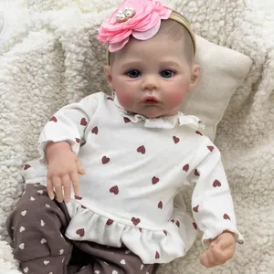Close-up of realistic 46cm reborn baby doll with blue eyes and pink floral headband