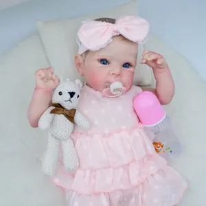 Realistic 18-inch reborn baby doll with blue eyes, pink lace outfit and bear toy accessories