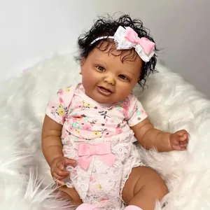 Realistic 60cm reborn baby doll with dark skin, curly hair and pink floral outfit