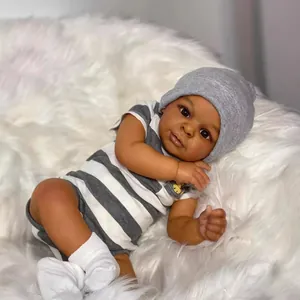 Realistic 23-inch deep skin reborn baby doll Jaylan in grey striped onesie on plush rug