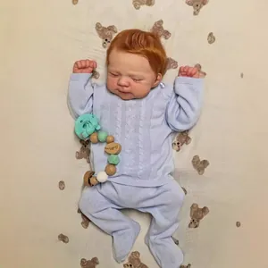 Lifelike 19 inch newborn reborn baby doll in blue knit outfit on cute bear patterned bedding