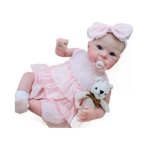 Realistic 18-inch reborn baby doll Bettie in pink lace dress with a plush white bear toy