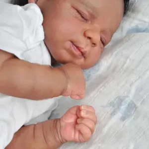 Poupée nouveau-né Reborn réaliste dormant en body blanc sur une couverture à éléphants