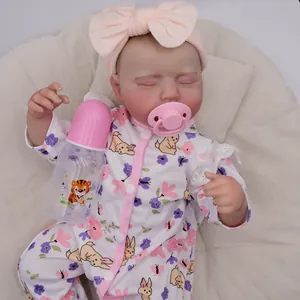 Lifelike 19-inch reborn baby doll sleeping in floral outfit with pacifier and bottle