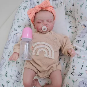 Close-up of sleeping Rosalie reborn doll with magnetic pacifier and pink baby bottle